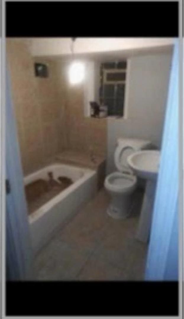 full bathroom with a shower, tile patterned flooring, a sink, and toilet