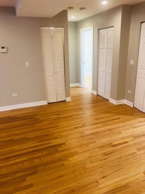 unfurnished bedroom with recessed lighting, light wood-type flooring, and baseboards