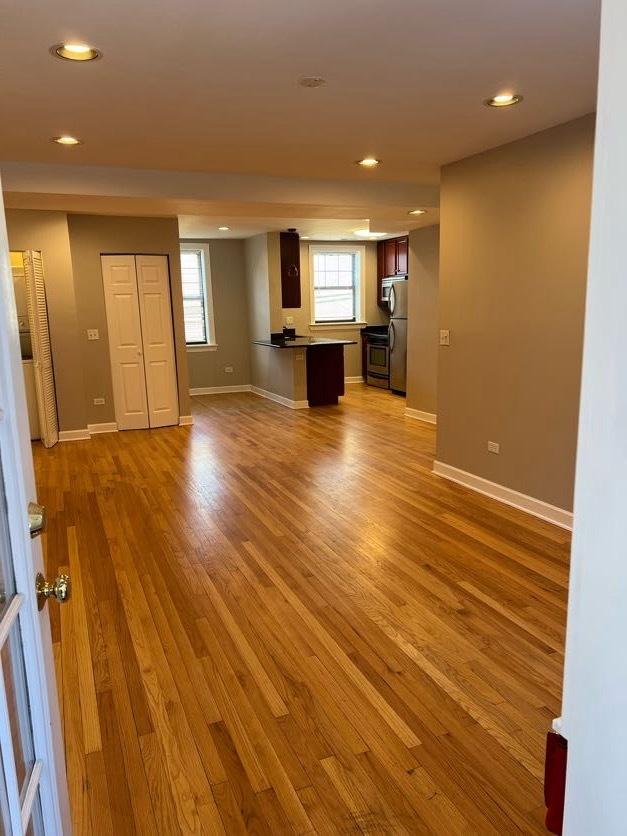 unfurnished living room featuring baseboards, wood finished floors, and recessed lighting