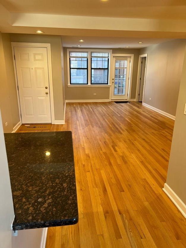 interior space with wood finished floors and baseboards