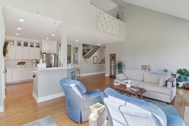 living area featuring recessed lighting, baseboards, light wood-style floors, and high vaulted ceiling