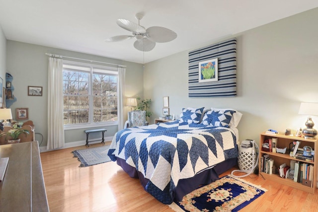 bedroom featuring ceiling fan, baseboards, and wood finished floors