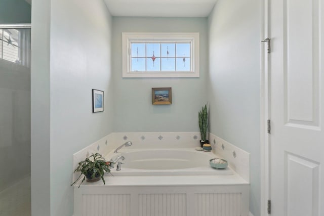 bathroom with plenty of natural light, a garden tub, and walk in shower