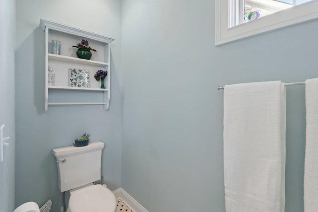 bathroom with toilet and baseboards