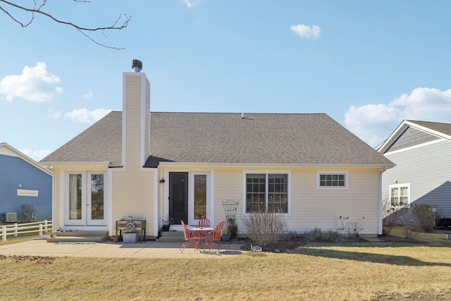 rear view of property with a patio, fence, roof with shingles, a yard, and french doors