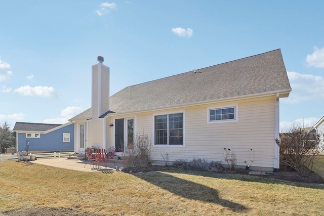 rear view of property with a patio area, a lawn, entry steps, and a chimney