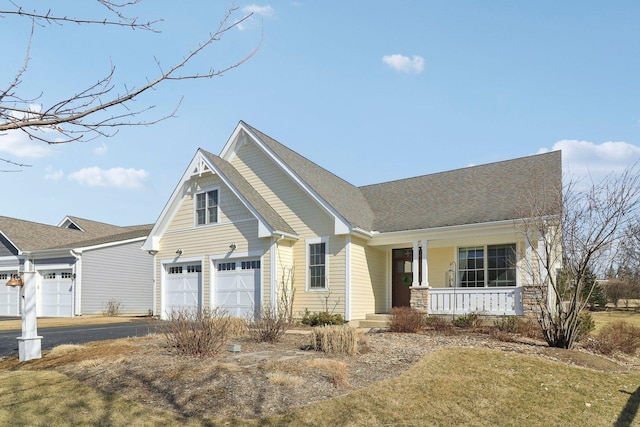 view of front of home featuring a garage, roof with shingles, covered porch, and driveway