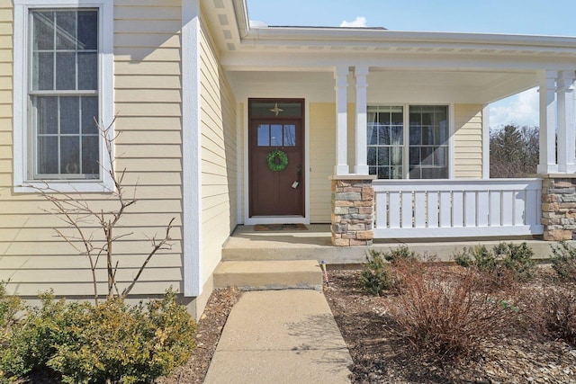 property entrance featuring stone siding and a porch