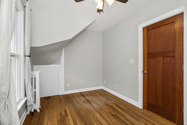 bonus room with hardwood / wood-style floors, a ceiling fan, and baseboards