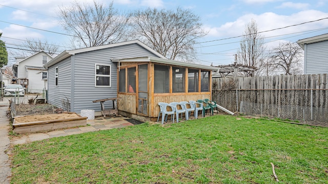 exterior space featuring a garden, a sunroom, a fenced backyard, and a yard