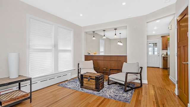 living area featuring light wood-style floors, baseboards, a baseboard heating unit, and recessed lighting