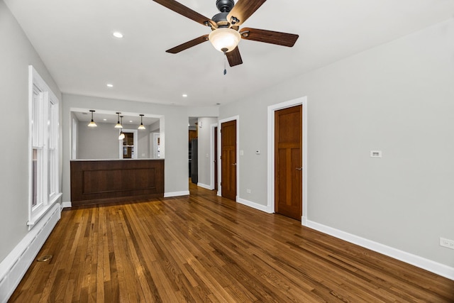 unfurnished living room featuring recessed lighting, a ceiling fan, baseboards, baseboard heating, and dark wood finished floors