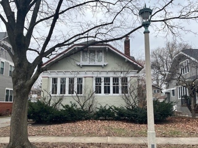 bungalow-style home featuring a chimney