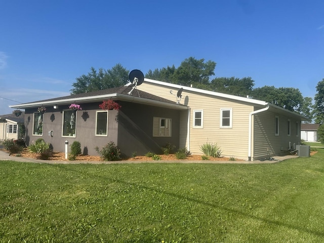 rear view of house featuring a yard and cooling unit