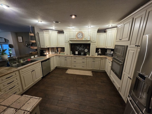 kitchen with dark wood-style flooring, visible vents, a sink, a peninsula, and black appliances