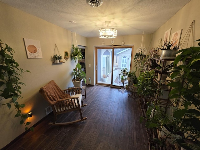 doorway to outside with a textured ceiling, dark wood-style flooring, and visible vents