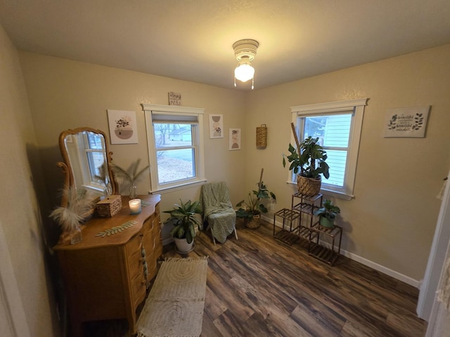 sitting room featuring a healthy amount of sunlight, dark wood finished floors, and baseboards