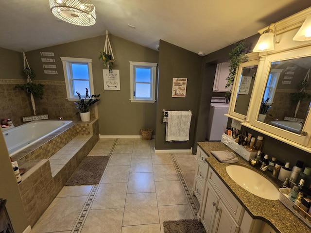 bathroom with lofted ceiling, tile patterned flooring, baseboards, a bath, and washer / clothes dryer