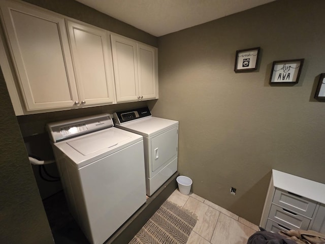 clothes washing area with cabinet space and separate washer and dryer