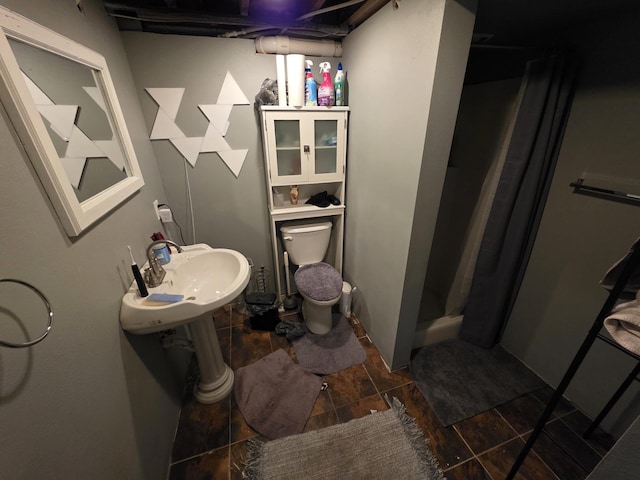 full bath with a stall shower, a sink, and toilet