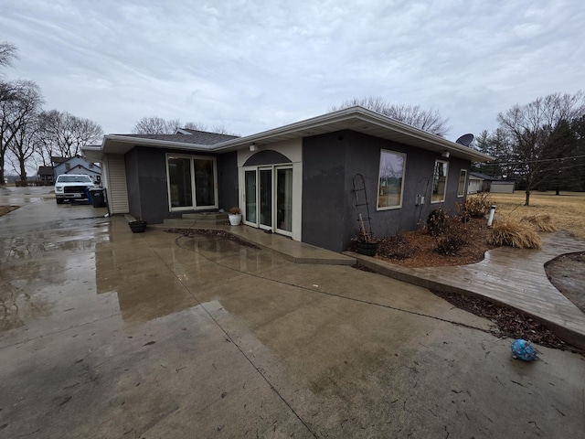 rear view of property featuring stucco siding