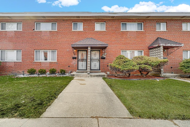 view of front of home with a front yard and brick siding