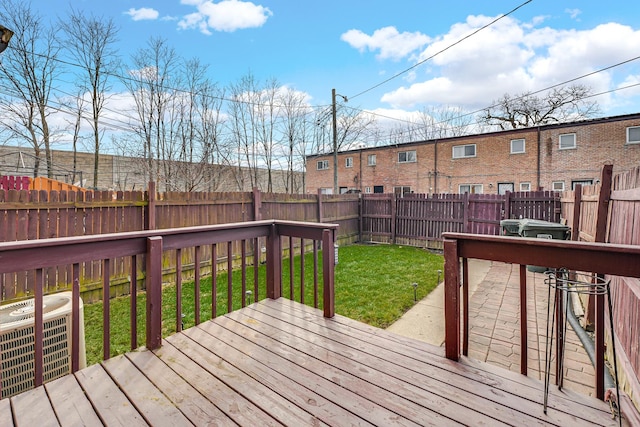 deck featuring a lawn, cooling unit, and a fenced backyard