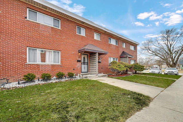 view of front of house featuring brick siding and a front lawn