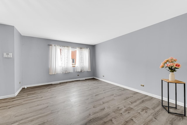 empty room featuring baseboards and wood finished floors