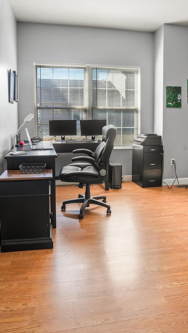 office area with a wealth of natural light, baseboards, and wood finished floors