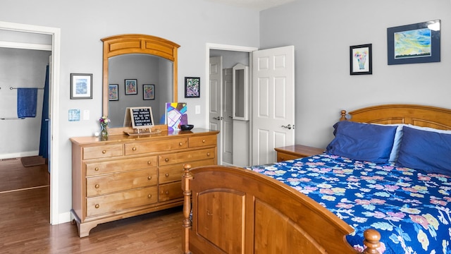 bedroom with baseboards and wood finished floors