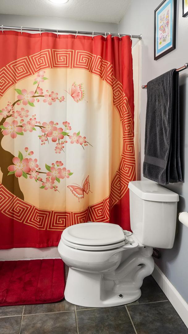 bathroom featuring tile patterned flooring, toilet, and baseboards