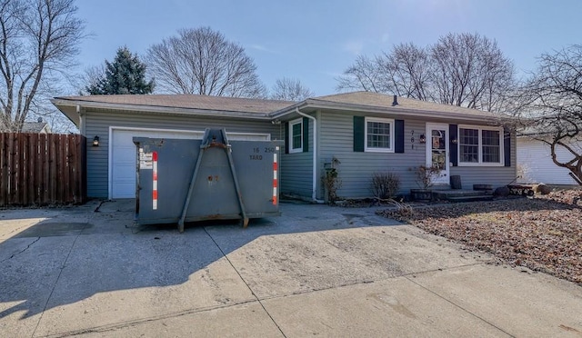 ranch-style home with an attached garage, fence, and driveway