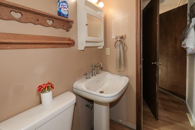 bathroom with a sink, toilet, and wood finished floors