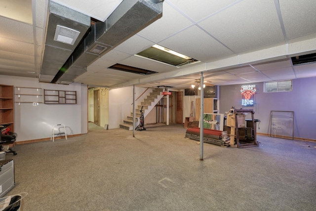 basement with stairway, baseboards, and a drop ceiling