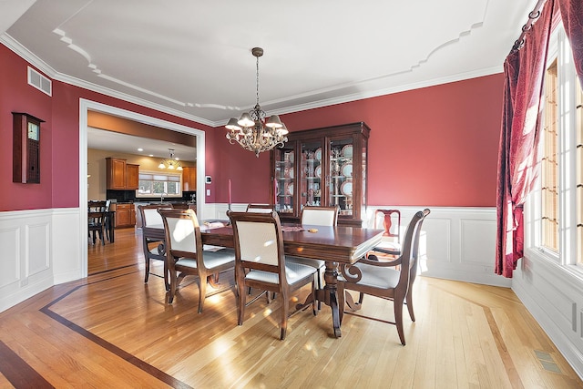 dining room with a chandelier, visible vents, and light wood-style floors