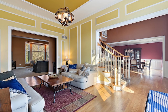 living room featuring stairs, visible vents, a decorative wall, and a notable chandelier