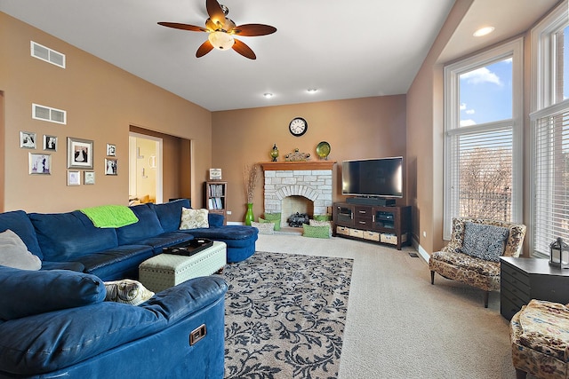 living area featuring a brick fireplace, visible vents, baseboards, and carpet flooring