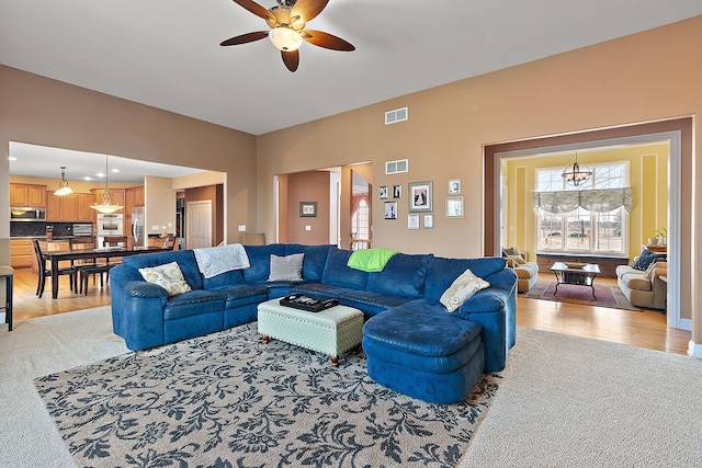 living area featuring a ceiling fan, light wood-type flooring, and visible vents