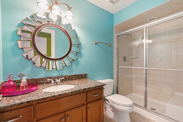 full bathroom featuring vanity, a shower stall, toilet, and tile patterned floors