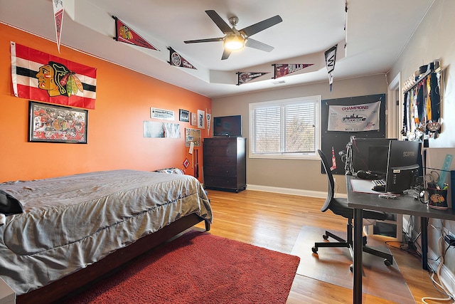 bedroom featuring track lighting, visible vents, baseboards, and wood finished floors