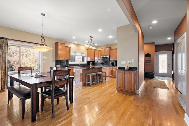 dining room with light wood-style floors, a wealth of natural light, and recessed lighting