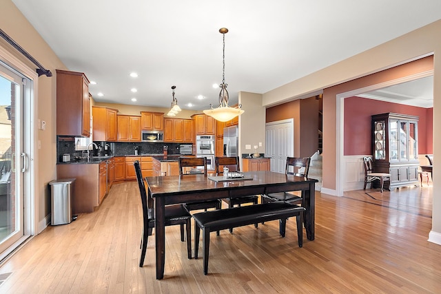 dining space with light wood-type flooring, stairway, and recessed lighting