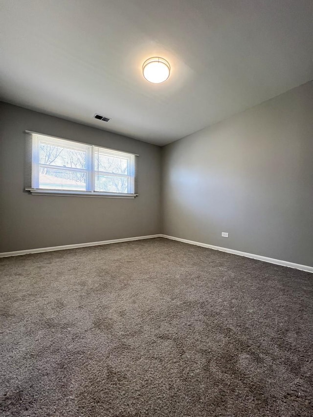 unfurnished room featuring carpet floors, visible vents, and baseboards