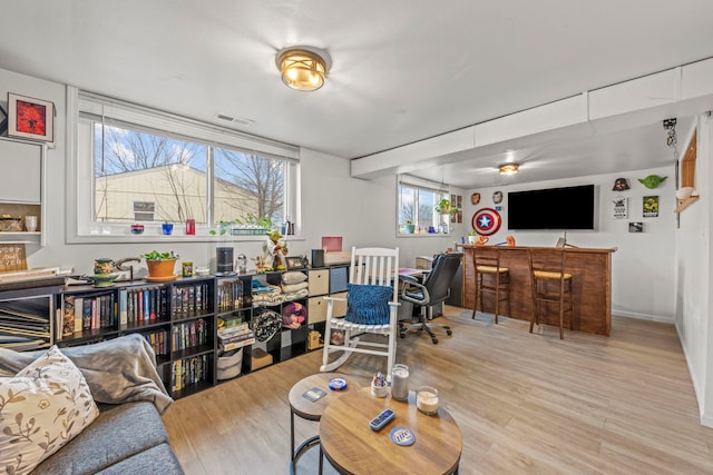 living area with visible vents, a dry bar, and wood finished floors