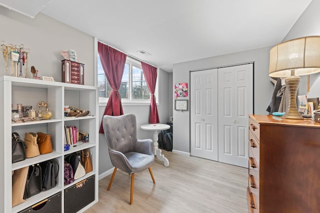 sitting room with light wood-type flooring, baseboards, and visible vents