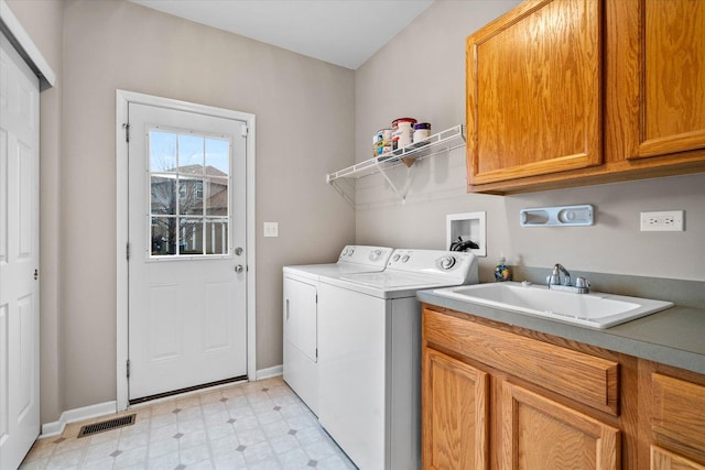 clothes washing area featuring a sink, visible vents, cabinet space, light floors, and washing machine and clothes dryer