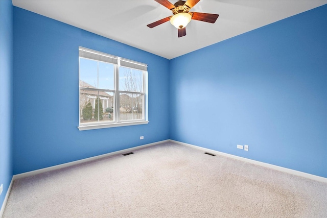 empty room featuring carpet, visible vents, and baseboards