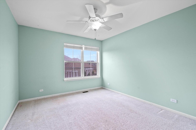 empty room featuring baseboards, carpet floors, visible vents, and a ceiling fan