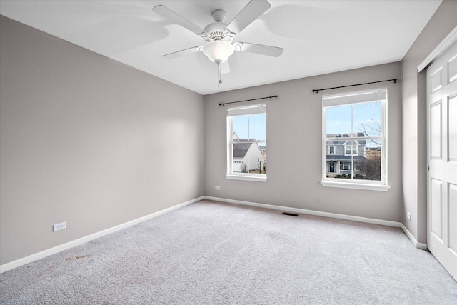 unfurnished room featuring visible vents, baseboards, a ceiling fan, and light colored carpet